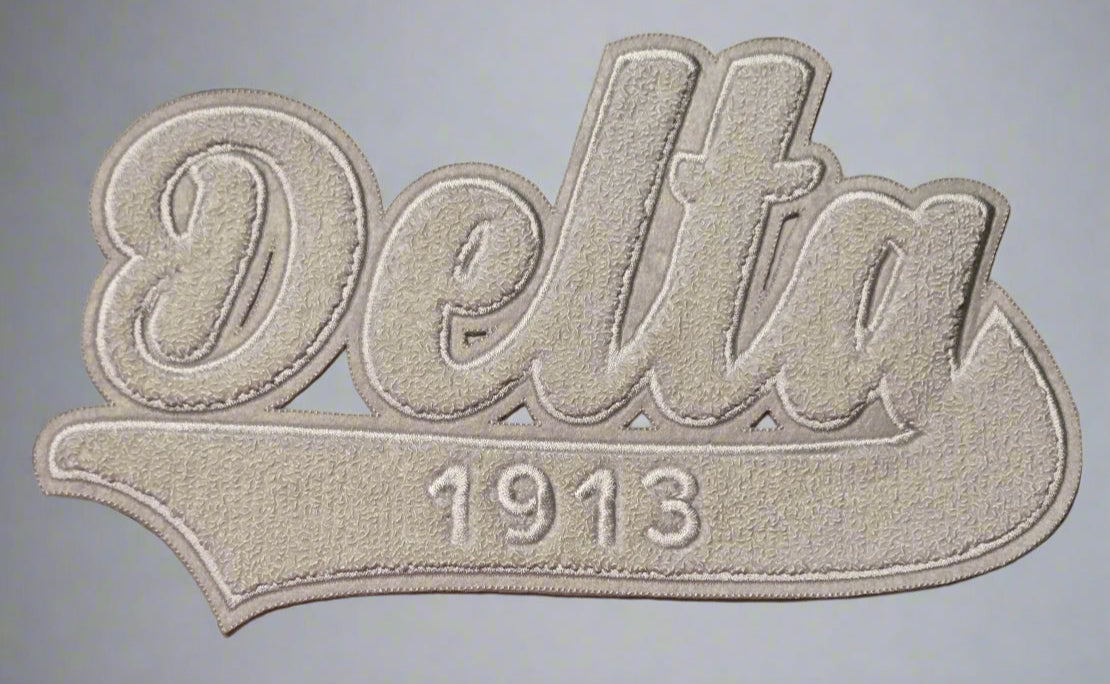 Embroidered patch with 'Delta 1913' text on a marble background