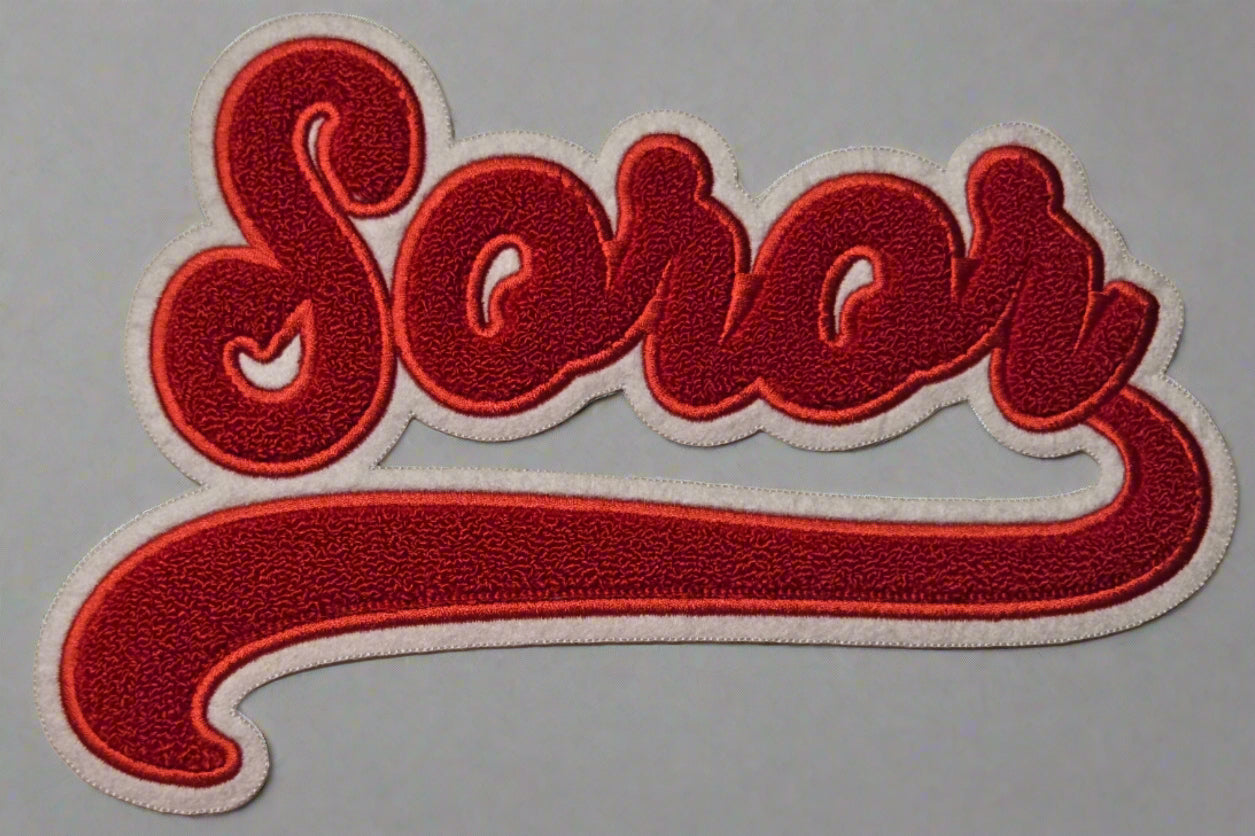 Embroidered patch with the word 'Soror' in red on a white background