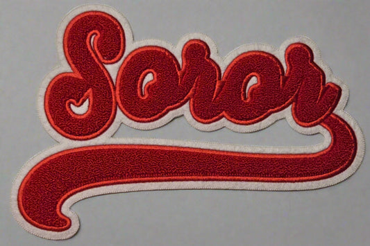 Embroidered patch with the word 'Soror' in red on a white background