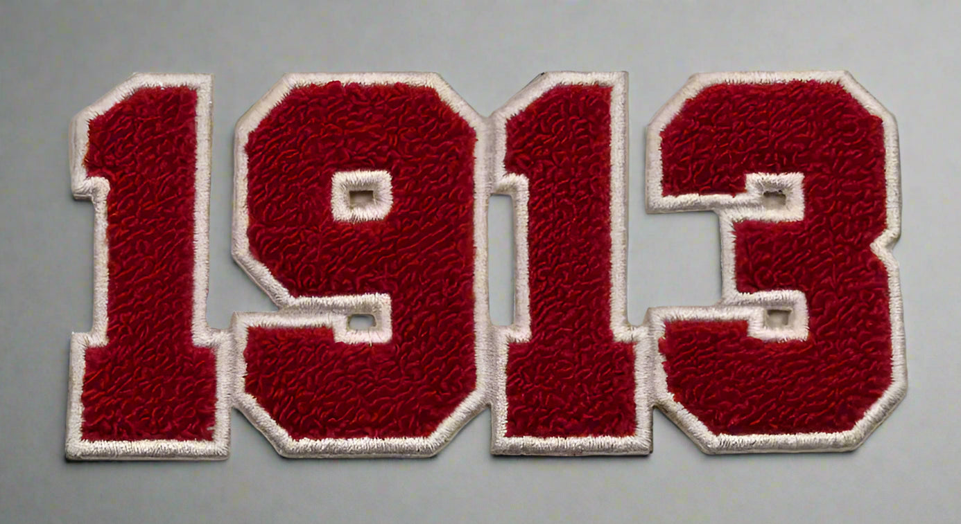 Patch with '1913' in red and white on a beige background