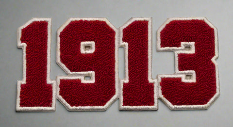 Patch with '1913' in red and white on a beige background