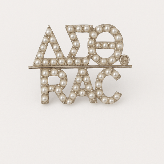 A pearl-encrusted pin featuring the DST Greek letters and the RAC symbol.