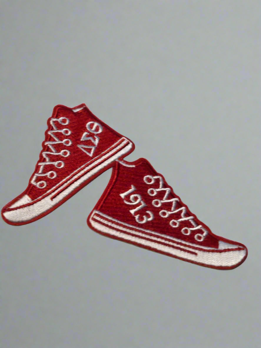 Red high-top sneakers patch with white laces on a beige background
