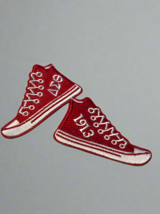 Red high-top sneakers patch with white laces on a beige background
