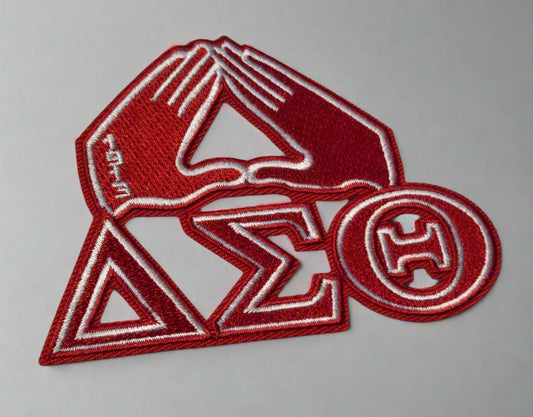 Red and white embroidered patch with symbols on a light gray background