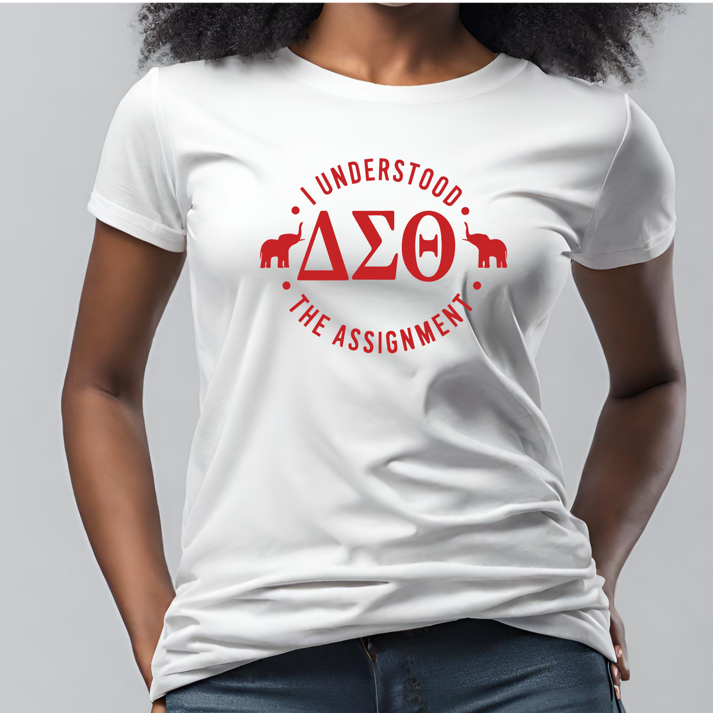 A woman wearing a white crew neck t-shirt with the text 'I understood the ASSIGNMENT' and Greek letters 'Delta Sigma Theta' in red.